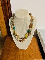 Full view of the vintage polished quartz and jade necklace displayed on a necklace stand, showing the bead arrangement and length.