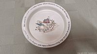 Top-down photo of the ceramic plate featuring a colorful Peter Rabbit garden scene and story text around the rim.