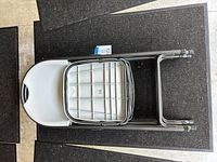 Top view of two stacked folding chairs showing white plastic seats and gray metal frames.