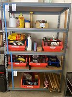 Front view of the shelving unit filled with various items on shelf trays, showing the overall structure and shelf material.