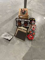 View of all decorative masks, empty photo frames stacked, and wood fish decor on basement floor