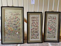 Photo showing all three framed embroidered panels side by side, largest to smallest