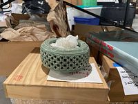 Asian inspired ceramic ashtray on top of original wooden box with red seal/stamp inside lid and additional items around