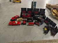 Wide layout of all toy cars, some boxed, some unboxed, showing various Ferrari models and some other cars.