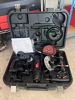 Open Craftsman black carrying case showing all-in-one cutting tool and multiple accessories including sanding discs and cutting blades.