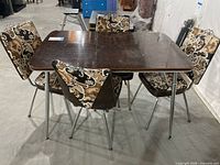Full view of the rectangular dinette table with four matching chairs around it showing the overall condition and features.