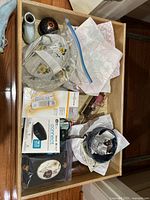 Top view of a drawer holding various items including serving dishes, pottery, electronics, collectibles, and kitchen tools.