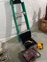 Full view of Werner three-step ladder standing next to an open black toolbox containing a Dewalt cordless drill and charger, a yellow drill bit case, and multiple clear plastic boxes with assorted hardware.
