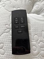Black remote control placed on mattress top