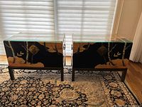 Front view of both tables side by side on patterned rug with shades-drawn window behind