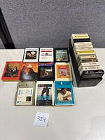 Full view of all 8-track tapes arranged on a table, showing labels and cases.