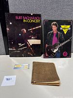 Photo showing Burt Bacharach in Concert program, Rick Springfield Club folder, Bobby Brown ticket stub, and vintage sheet music
