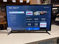 32 inch onn. Roku smart TV powered on showing Roku home screen with input and app selection menu.