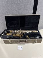 Full view of Selmer Bundy alto saxophone inside its open hard case with shoulder strap.