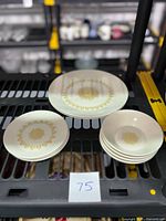 Full view of the Sheffield Serenade dinner plates, bread plates, and dessert bowls showing gold sunburst pattern and white ceramic.