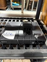 Top view of the Sony Blu Ray DVD player showing power adapter placed on top with visible front Sony logo.