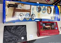 Lot showing unopened Simple Clean telescoping duster packaging, Thermophore moist heat pack box, and folded Men's Warehouse garment bag