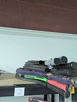 Stacked seven assorted tennis racquets with visible wear on grips and frames