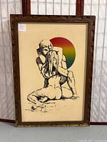 Full view of framed velvet painting showing embracing couple and wooden frame with mildew on bottom.