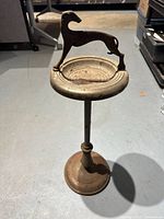 Full view of the ashtray stand with greyhound figure on top, showing overall structure and condition.