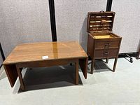 Photo showing the vintage coffee table with a wooden frame, glass top, expandable sides and a drawer visible underneath.