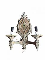 Front view of the double candle wall sconce showing two sockets, ornate detailing, and original paint.