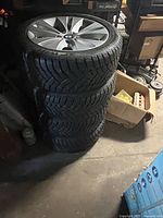 Four mounted wheels stacked in garage
