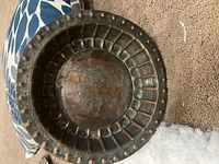Top-down view of the stamped copper silvered bowl showing floral and geometric patterns with a studded raised rim.