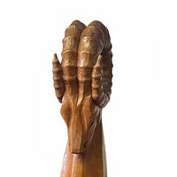 Front view of the hand-carved teak wood ram sculpture showing the detailed horns and head.