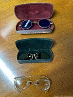 Three pairs of antique eyewear shown, two pairs with original cases and one without case