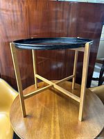 Photo of the black tole round tray on the folding wooden stand showing overall view