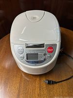 Front view of white Tiger rice cooker showing control panel with digital display and function buttons