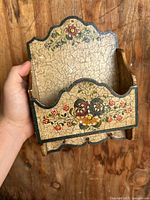 Front view of the wooden key and mail hanger showcasing the floral hand painted design and the crackled finish.