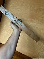 Photo of the wooden carpenter's level showing the top and side surfaces with bubble vial.