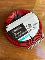 Coiled red galvanized steel cable with Everbilt label showing product name, capacity and dimensions.