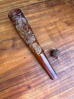 Full view of the wooden carved dragon rattle on wooden surface.