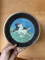 Full frontal view of the round plate showing central horses design and border