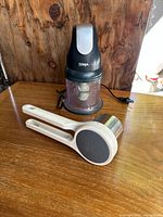 Ninja food processor and Joseph Joseph food stringer on wooden surface.