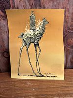 Full view of art print showing llama with decorated obelisk, gold background, curling edges