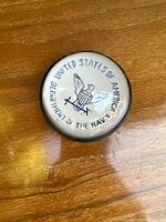 Top view of glass paperweight showing United States of America Department of the Navy emblem.