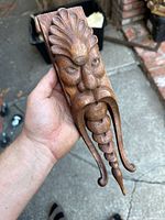 Front view of the carved oak face mask showing detailed facial features and long beard.