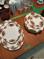 Large oval platter at left, medium oval platter at center and stack of dinner plates at right on table