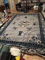 Full view of the rectangular wool area rug with Chinese style design in a living room setting.