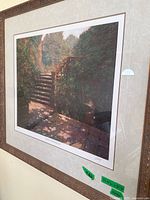 Framed art print showing stairs outdoors with greenery and shadows, with visible signature and numbering on bottom right and title on bottom center.