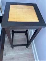 Top view of the square night table showing bamboo slats top insert and dark wood frame with minor wear.