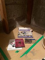 Photo showing a box with assorted coins, plastic holders, and coin booklets spread on the floor.