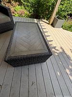 View of the outdoor coffee table on a deck with the rectangular planter in the background to the right.