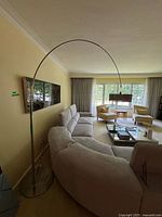 Overall view of arched floor lamp in living room showing base, arch and shade