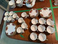 Overview of all pieces on table: teapot, sugar, creamer, dinner plates, saucers, cups and mugs