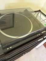 Full view of Technics turntable with closed transparent dust cover and control buttons on front side.